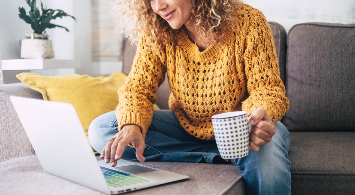 Woman working on laptop drinking coffee