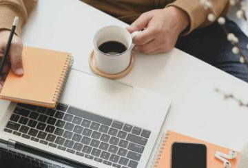 Man drinking coffee at computer