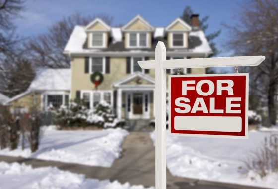 Home For Sale Sign in Front of Snowy New House