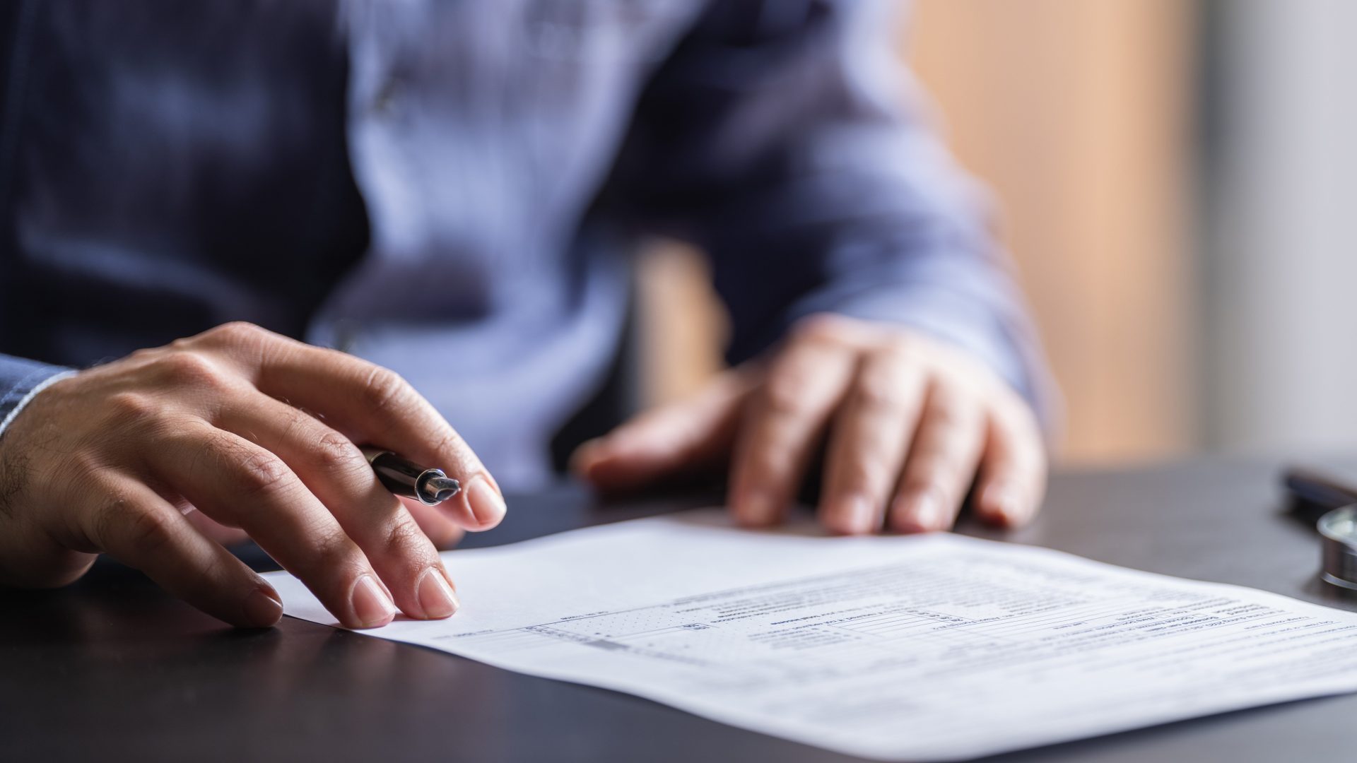 hands signing a paper