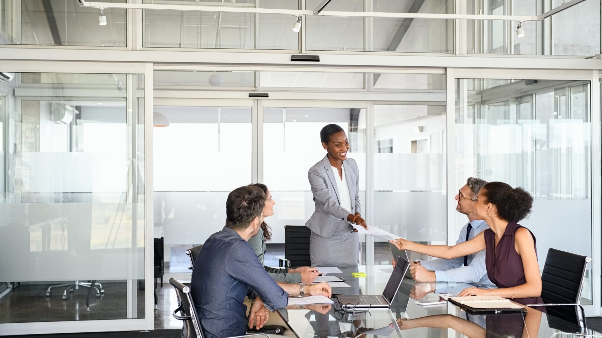 Smiling business people sharing document in meeting