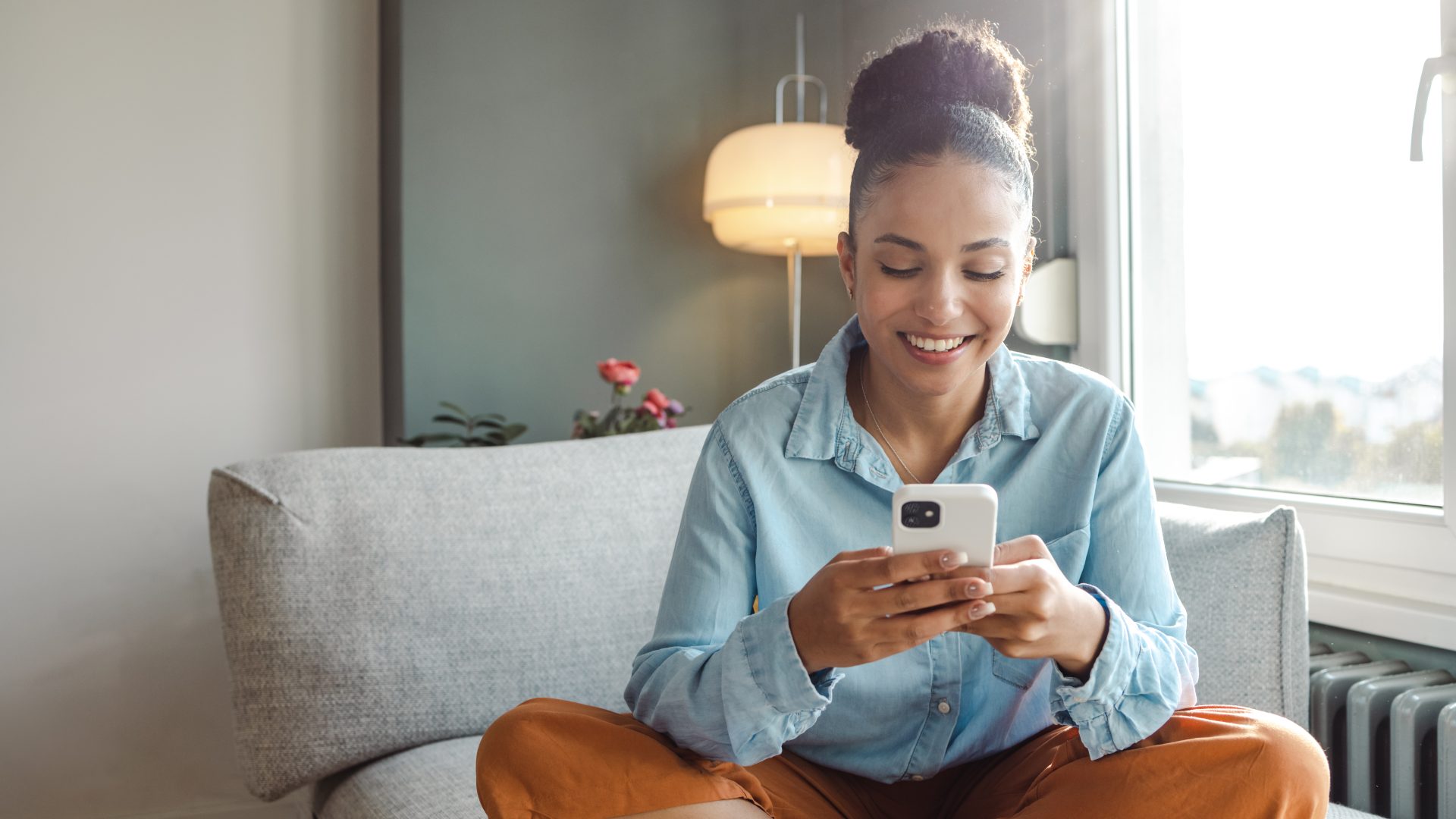 A young beautiful woman using a smart phone at home