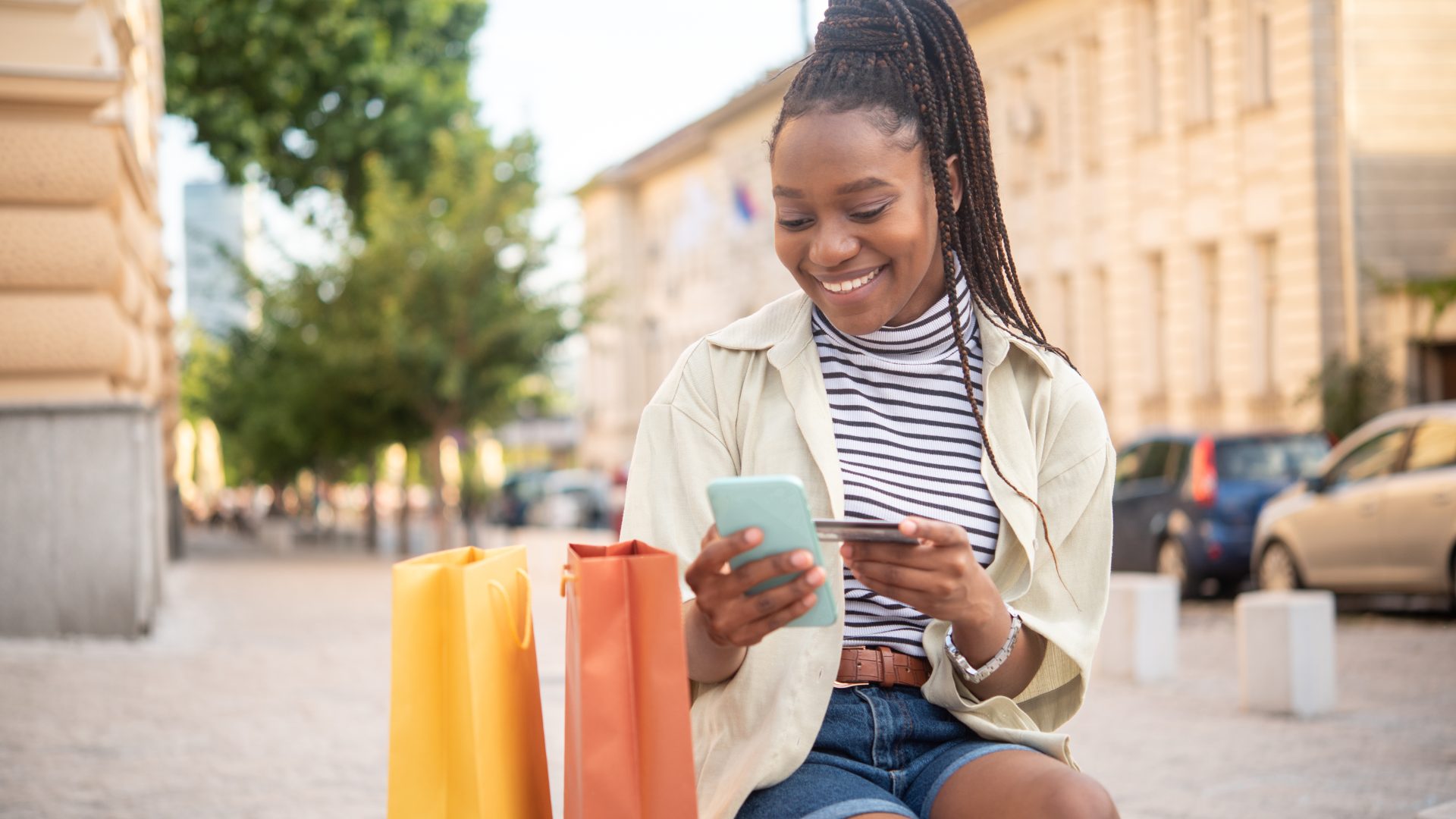 Happy woman shopping online and enjoying in the city