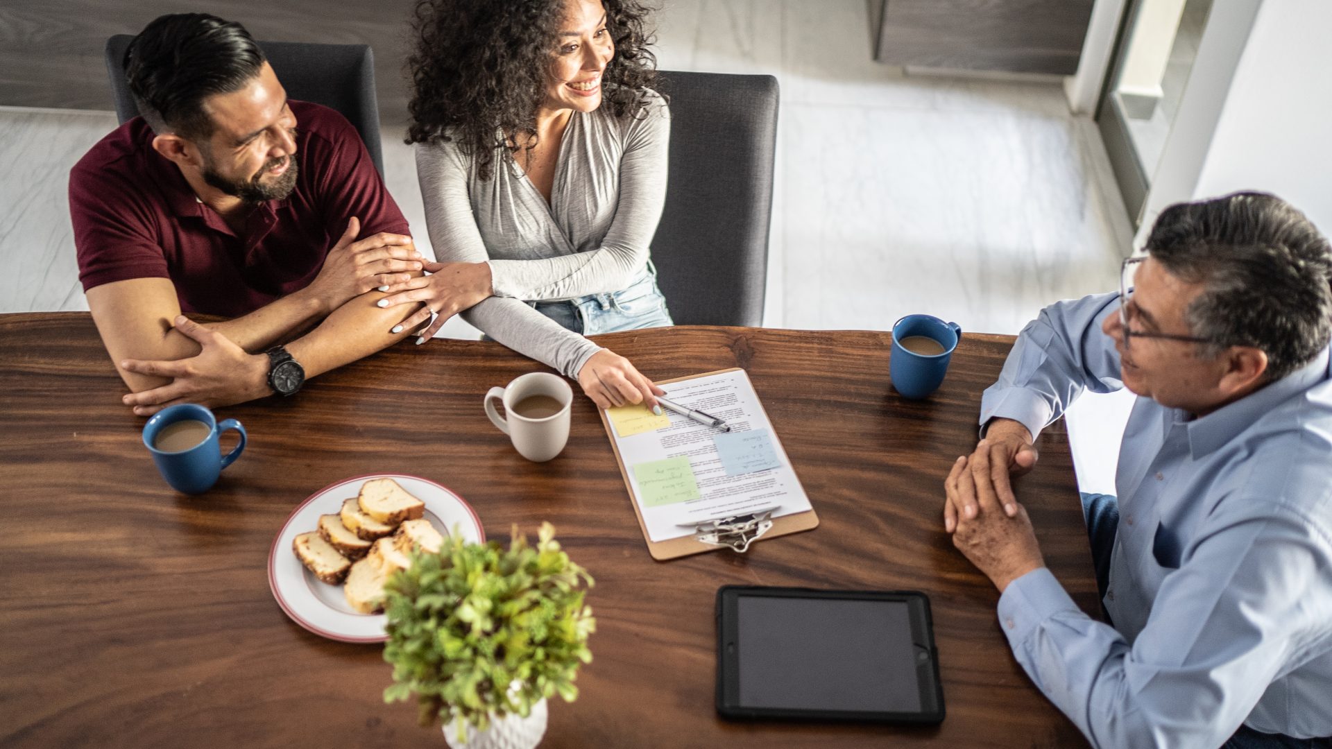 Mid adult couple having a meeting with real estate agent (or financial advisor) at house