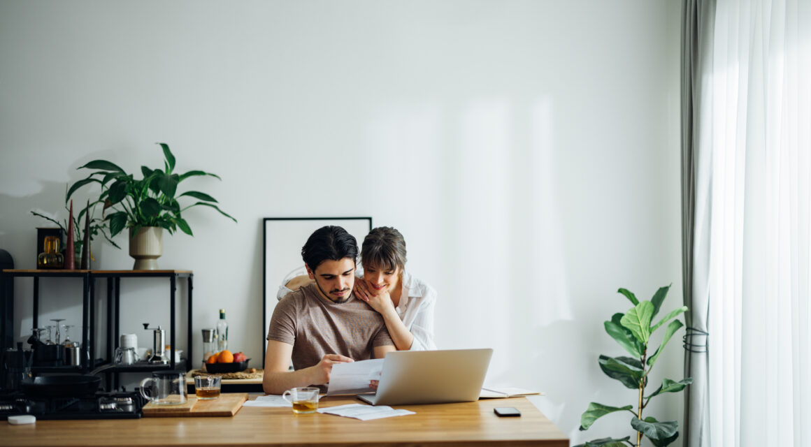 Smiling Couple Paying Bills at Home