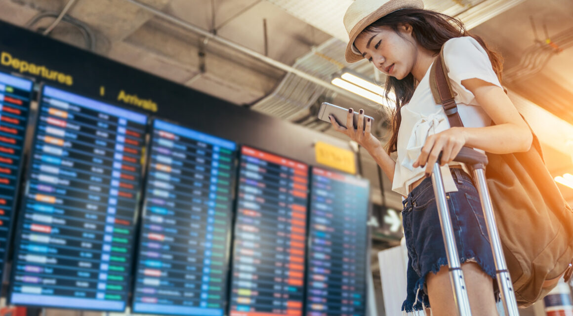 girl in airport looking at smartphone