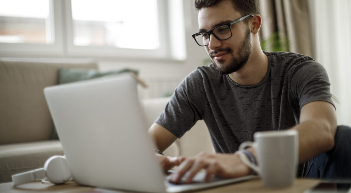 Teenage boy using laptop at home