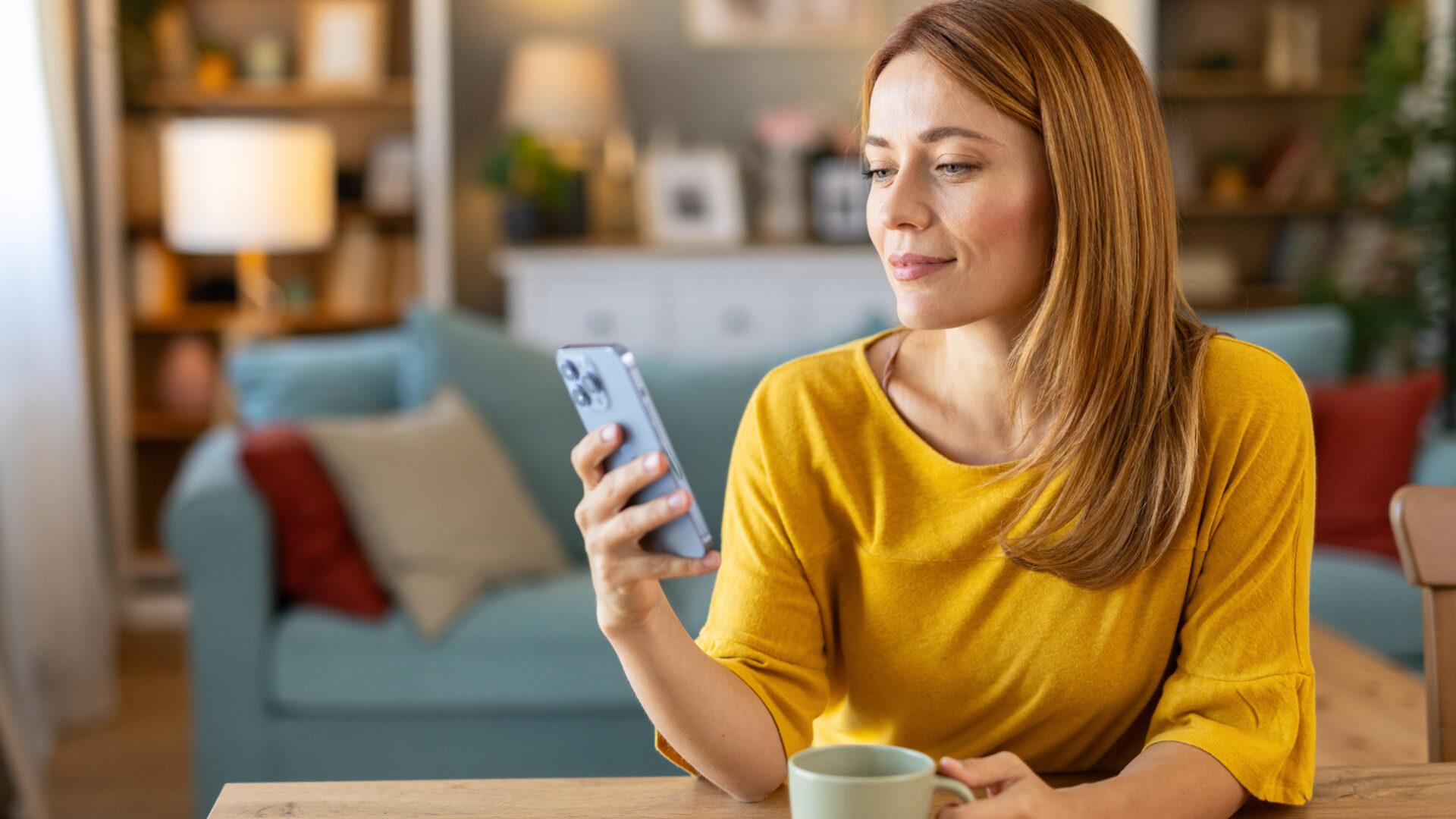 Woman Enjoying Coffee While Using Smartphone at Table