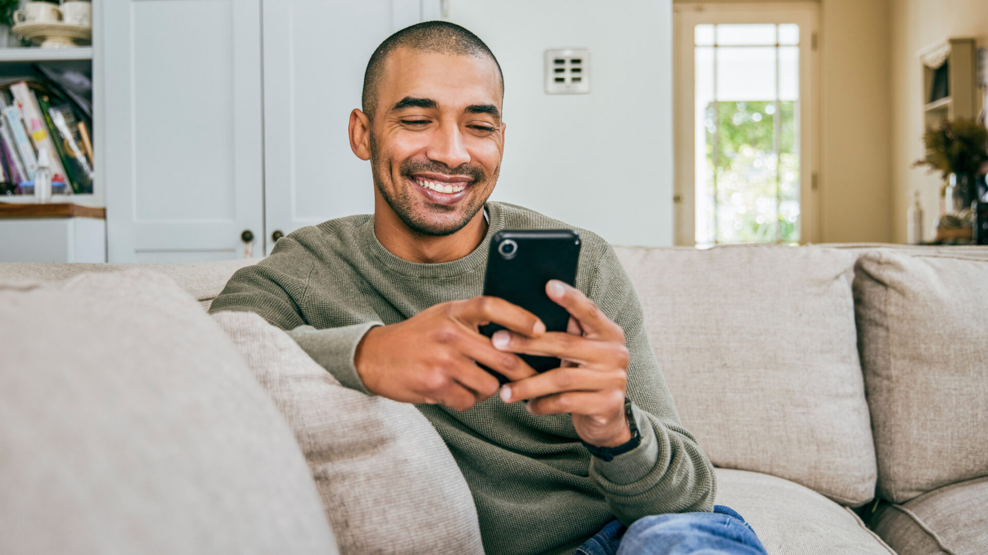 Shot of a young man using his smartphone to send text messages