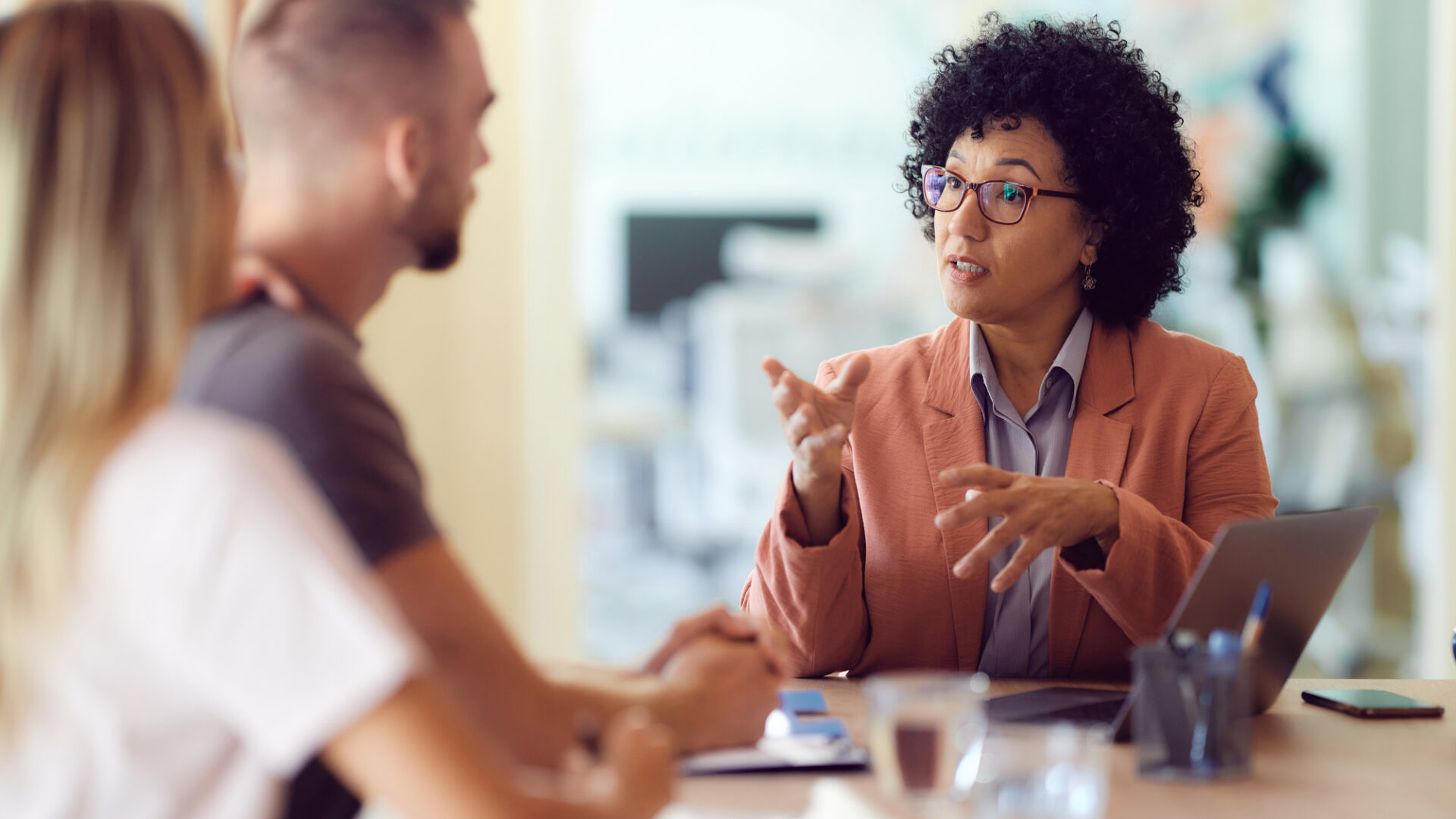 Female agent talking to her customers on a meeting in the office.
