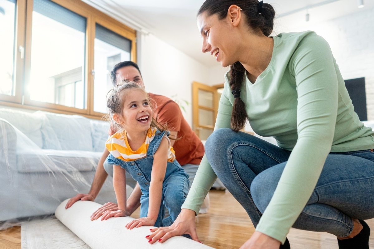 Caucasian family rolling out a carpet